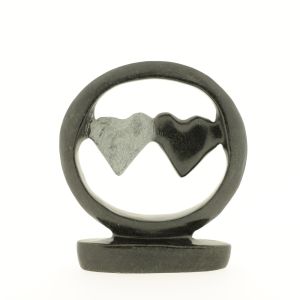 Op de foto een beeld van twee harten in een cirkel. Handgekapt in zeepsteen. Het ene hart gepolijst en het andere hart blanke steen. Fairtrade uit Zimbabwe. Deze liefdevolle sculptuur staat in elk interieur.