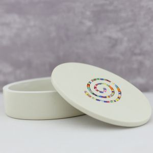 Bewaardoosje, mini-urn of juwelendoosjes in wit natuursteen. Het deksel ingelegd met een slinger van gekleurde kraaltjes. Mooi vormgegeven, heel decoratief en bijzonder om speciale dingetjes in te bewaren.