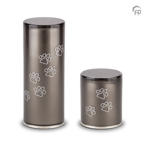 Foto van twee dier urnen, een klein en groter cilindervormig model met witte pootafdrukken om hoog lopend over de urn. Deze as bestemming heeft een antraciet kleur en is prachtig vormgegeven in Boheems glas.