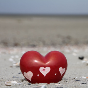 Een prachtig hand bewerkt spekstenen hart. Rood afgewerkt met hierin hartjes en puntjes uitgesneden. Staat heel sfeervol in het strandzand. Prachtige decoratie voor vele gelegenheden.